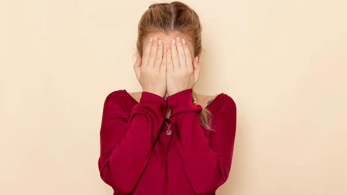 Yüzünü elleriyle kapatan genç kız, reşit olmayanla cinsel ilişki konulu içerik